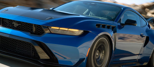 A striking front-profile view of the 2026 Ford Mustang GTD, highlighting its aggressive carbon fiber front splitter and vented fenders