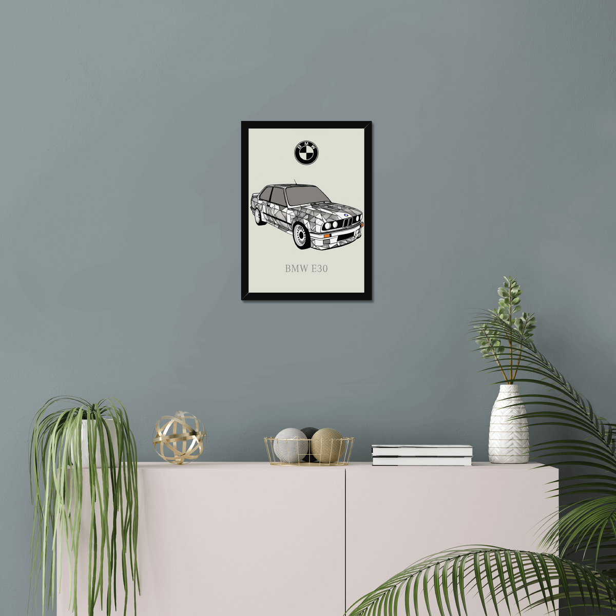 BMW E30 black-framed print above a pink sideboard