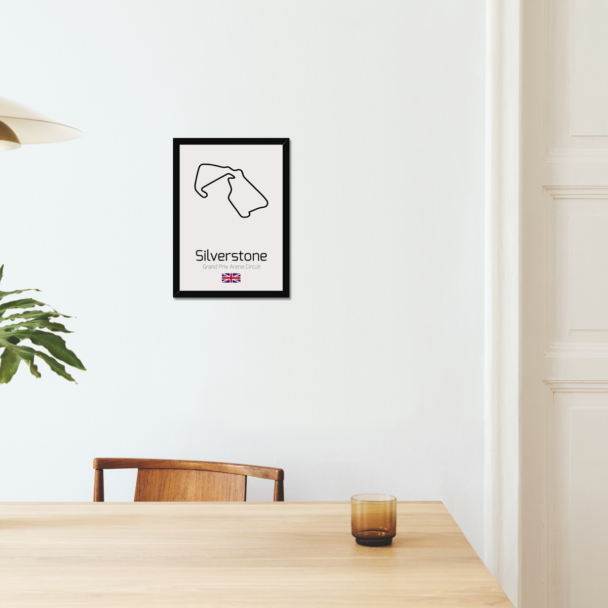 Silverstone black-framed print above a dining table